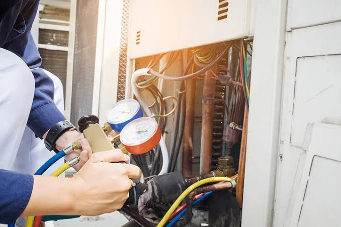 Technician using pressure gauges to diagnose HVAC equipment