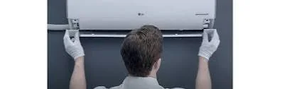 Installer positioning indoor HVAC equipment near an air distribution opening